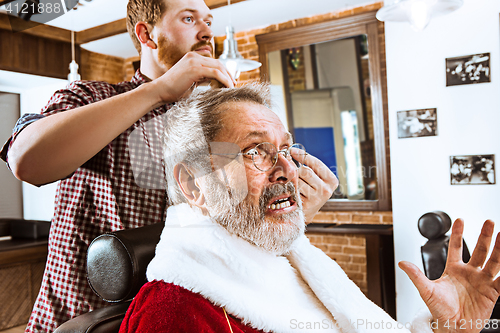 Image of Santa claus shaving his personal barber