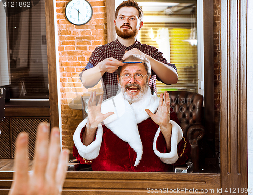 Image of Santa claus shaving his personal barber