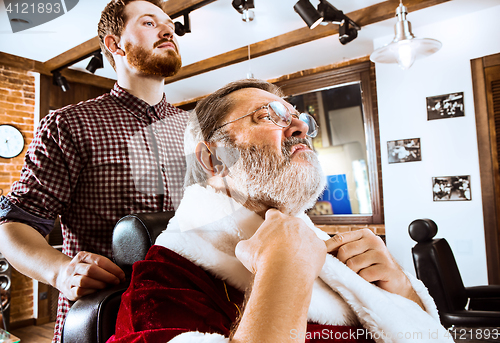 Image of Santa claus shaving his personal barber