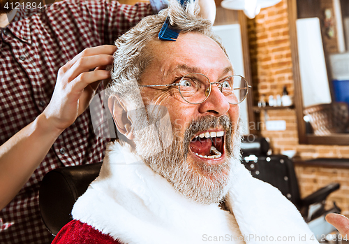 Image of Santa claus shaving his personal barber