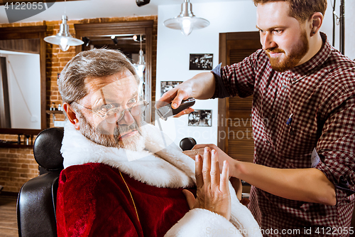 Image of Santa claus shaving his personal barber