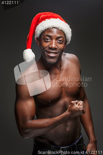 Image of Muscular black shirtless young man in Santa Claus hat