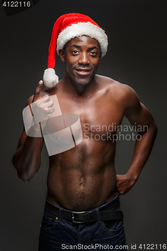 Image of Muscular black shirtless young man in Santa Claus hat