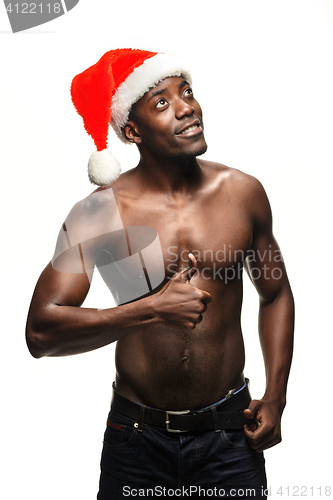 Image of Muscular black shirtless young man in Santa Claus hat
