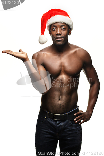 Image of Muscular black shirtless young man in Santa Claus hat