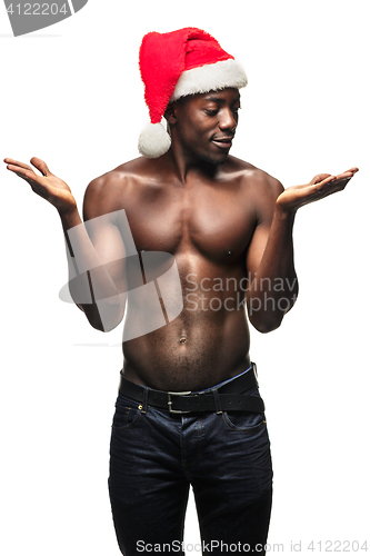 Image of Muscular black shirtless young man in Santa Claus hat