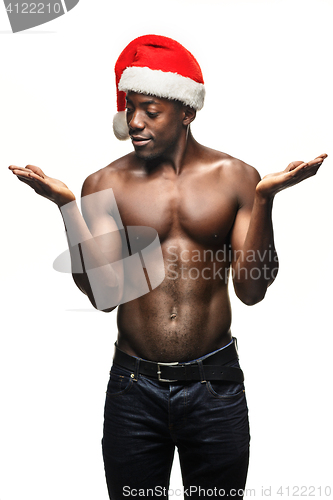 Image of Muscular black shirtless young man in Santa Claus hat