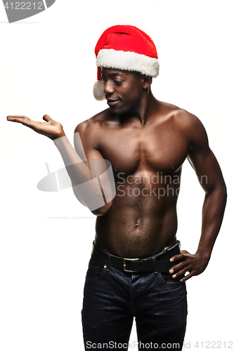 Image of Muscular black shirtless young man in Santa Claus hat