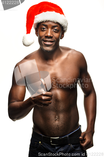 Image of Muscular black shirtless young man in Santa Claus hat