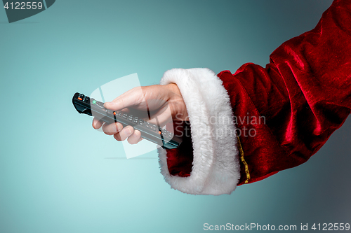 Image of Santa Claus holding tv remote control