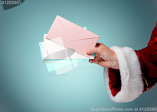Image of Hand in costume Santa Claus is holding the envelopes