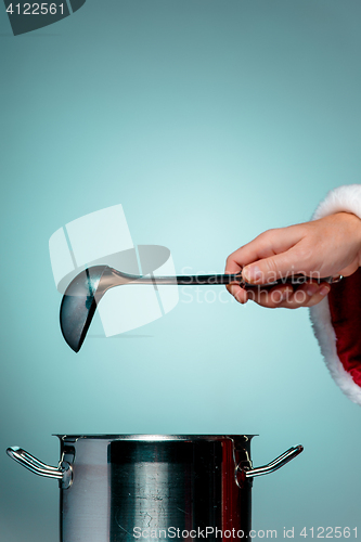 Image of The Santa hand holding a ladle or kitchen spoon