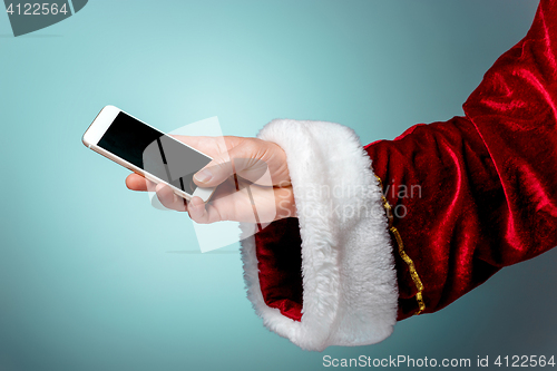 Image of Santa Claus holding mobile smartphone ready for Christmas time