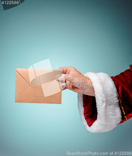 Image of Hand in costume Santa Claus is holding the envelope