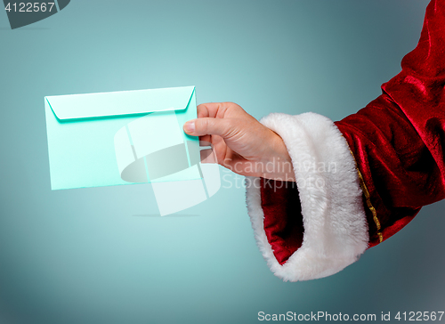 Image of Hand in costume Santa Claus is holding the envelope