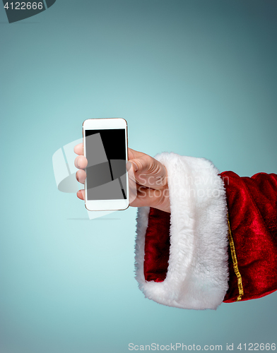 Image of Santa Claus holding mobile smartphone ready for Christmas time