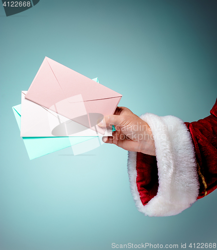 Image of Hand in costume Santa Claus is holding the envelopes