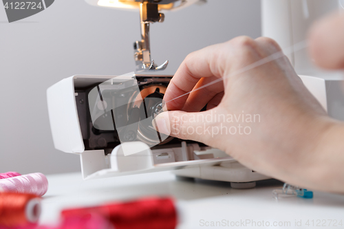 Image of Hand with spool of sewing-machine