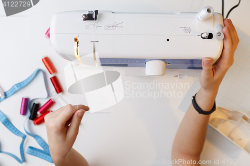 Image of Girl preparing work on sewing-machine