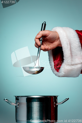 Image of The Santa hand holding a ladle or kitchen spoon