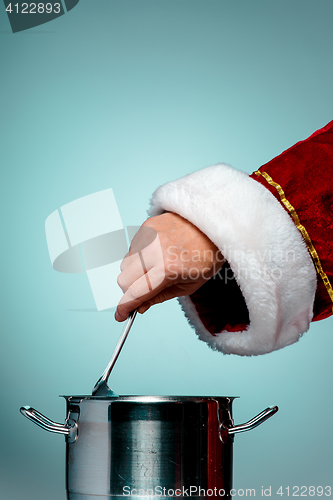 Image of The Santa hand holding a ladle or kitchen spoon