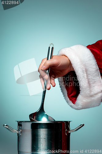 Image of The Santa hand holding a ladle or kitchen spoon