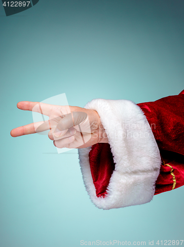 Image of Santa Claus hand showing sign victory with thumbs up