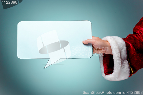 Image of Santa Claus hand presenting your text or product on blue background