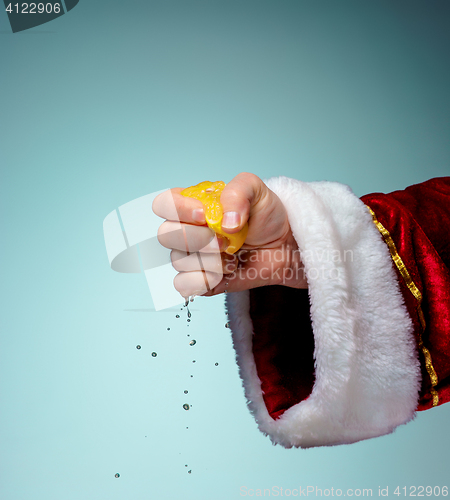 Image of Photo of Santa Claus hand squeezing lemon