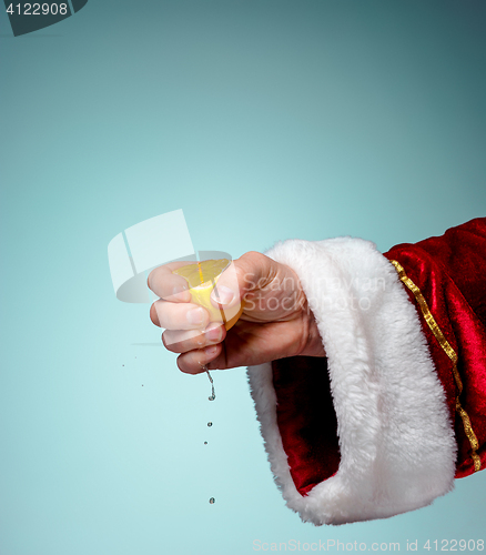 Image of Photo of Santa Claus hand squeezing lemon