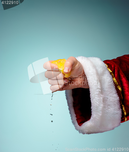Image of Photo of Santa Claus hand squeezing lemon