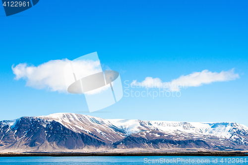 Image of Mountains with snow by the ocean