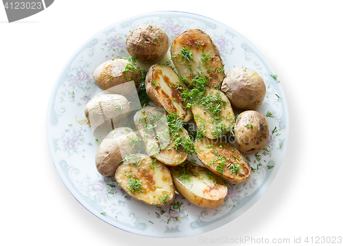 Image of Russian Traditional baked potatoes with the peel and fennel, drizzled oil on a plate gray ornament