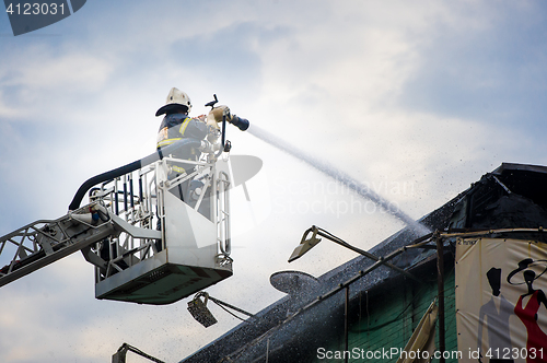 Image of Firefighters in action fighting, extinguishing fire, in smoke.