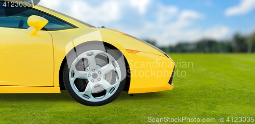 Image of Yellow Luxury Sport Car outdoor on green grass