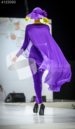 Image of Beautiful young blonde woman in purple dress covered oriental veil