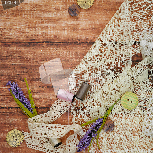 Image of Lace and thread on wooden background