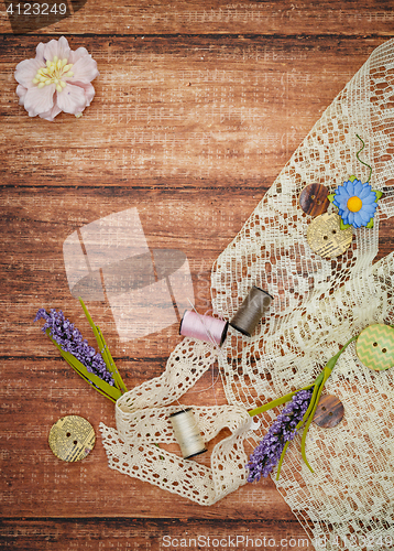 Image of Lace and thread on wooden background