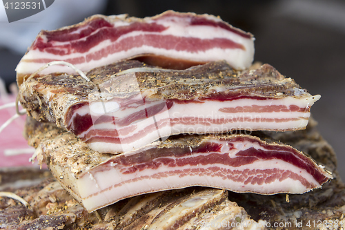 Image of Pieces of smoked bacon on a street stand