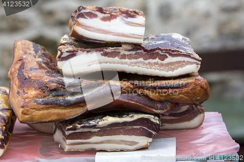 Image of Pieces of smoked bacon on a street stand