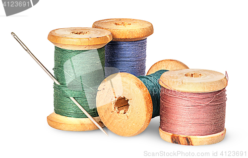 Image of Needle and multicolored thread on wooden spool