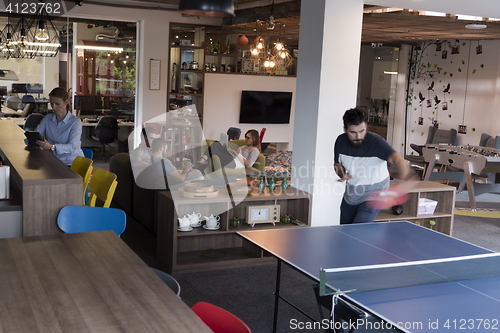 Image of playing ping pong tennis at creative office space