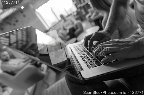 Image of close up of male hands while working on laptop