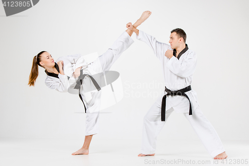 Image of The karate girl and boy with black belts