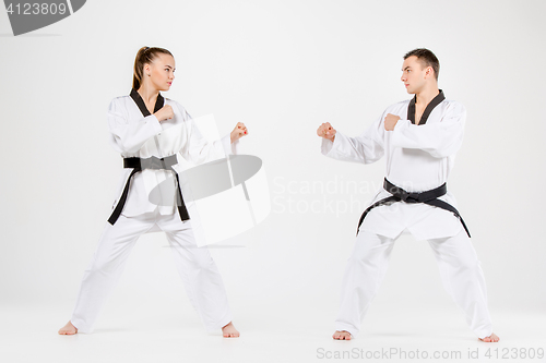 Image of The karate girl and boy with black belts