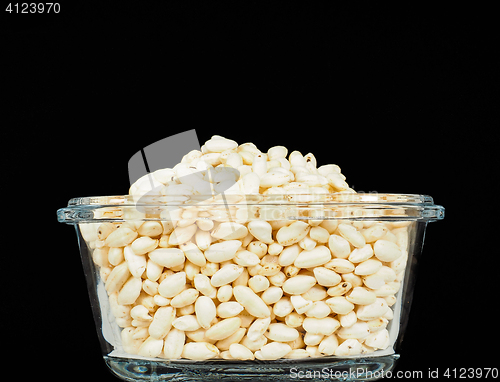 Image of Puffed rice in translucent square glass bowl, towards black