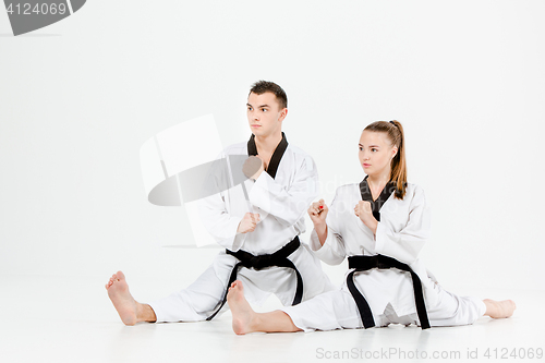 Image of The karate girl and boy with black belts