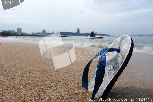 Image of Beach slippers on a sandy beach
