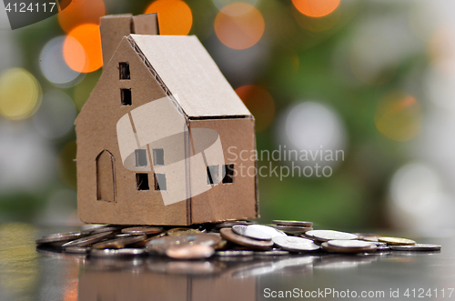 Image of Model of house with coins on wooden table