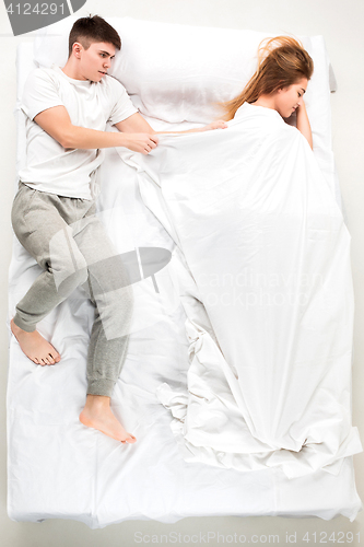 Image of The young lovely couple lying in a bed